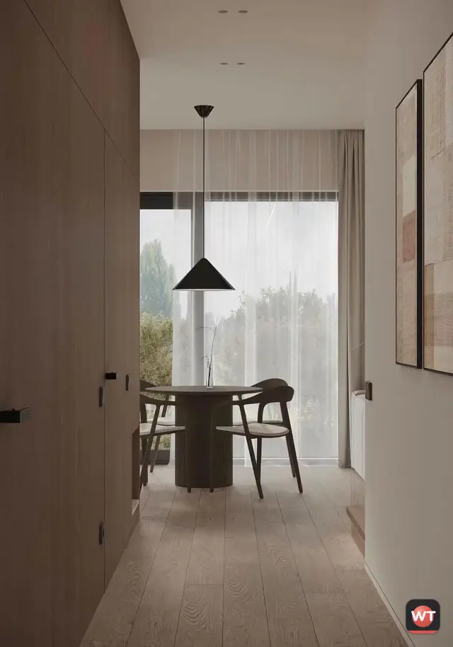 Corredor com parede revestida a nogueira e portas embutidas, com a sala ao fundo