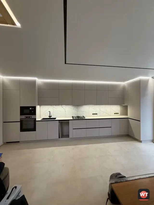 Cozinha branca montada, com LED no teto e sob os armários